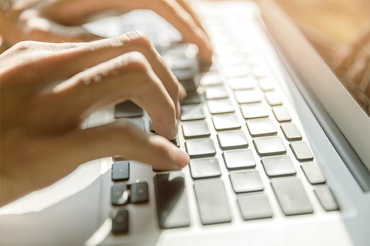 Hand typing on laptop computer