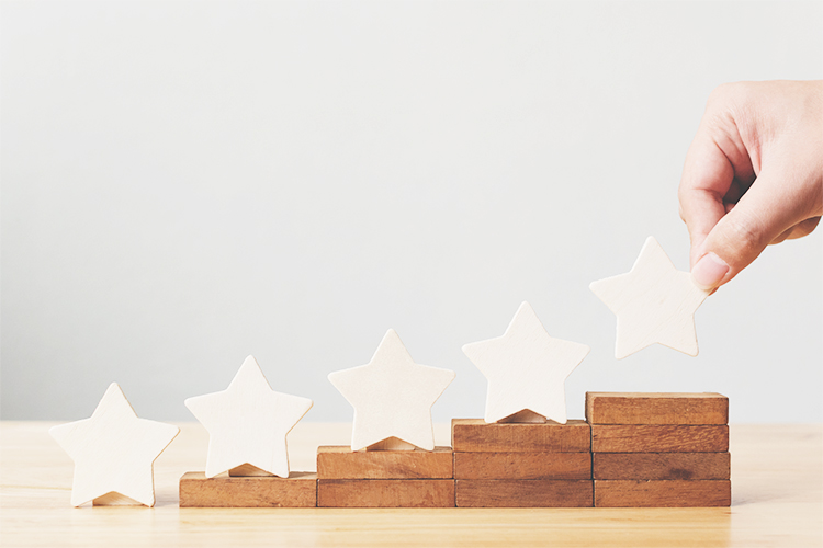 Five ascending wooden stars on wooden stairs