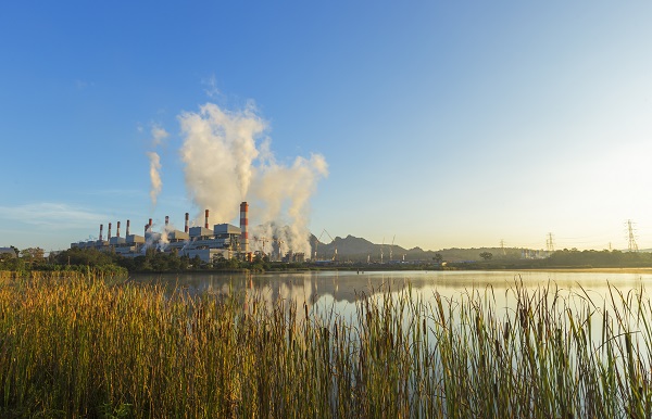 EMC photo of a river and power plant emitting smoke in the distance